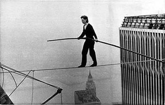 Philippe Petit op 415 meter hoogte. Let op het miniscule topje van het Empire State Building onder hem.